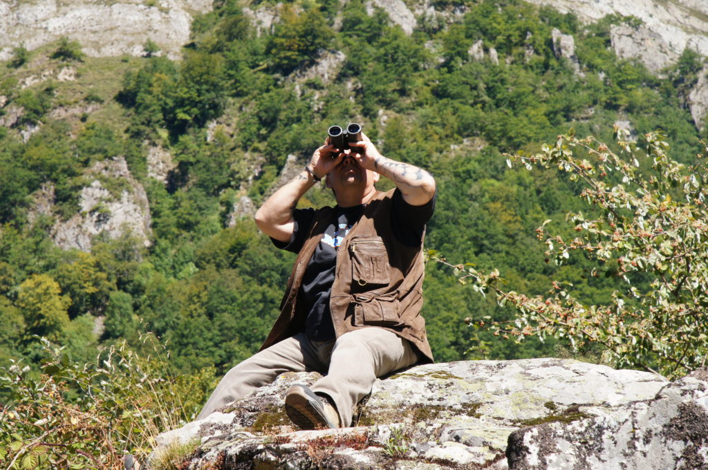 Birdwatching en Asturias. Un hombre observa aves con sus prismáticos.